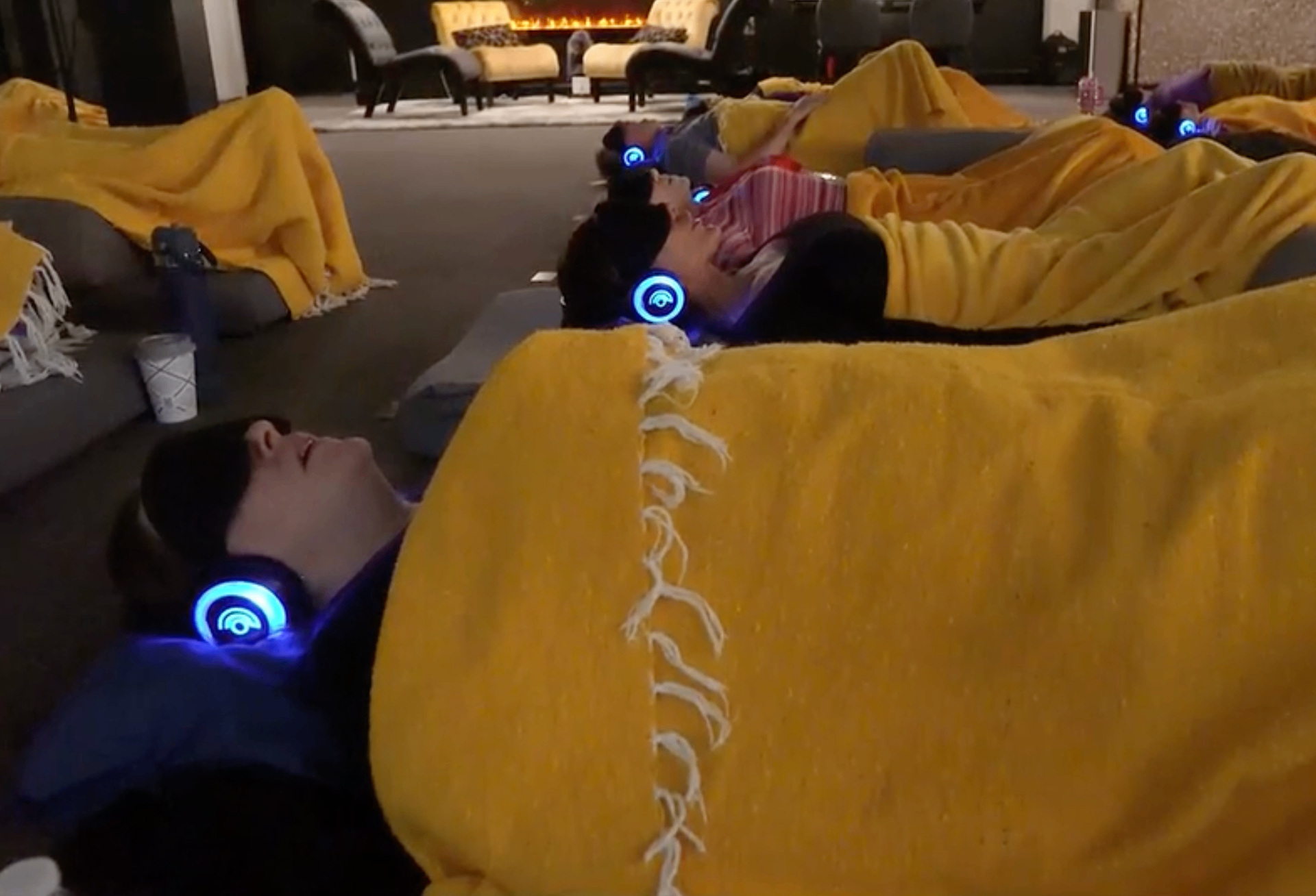 Guests resting by the fireplace with headphones and blankets